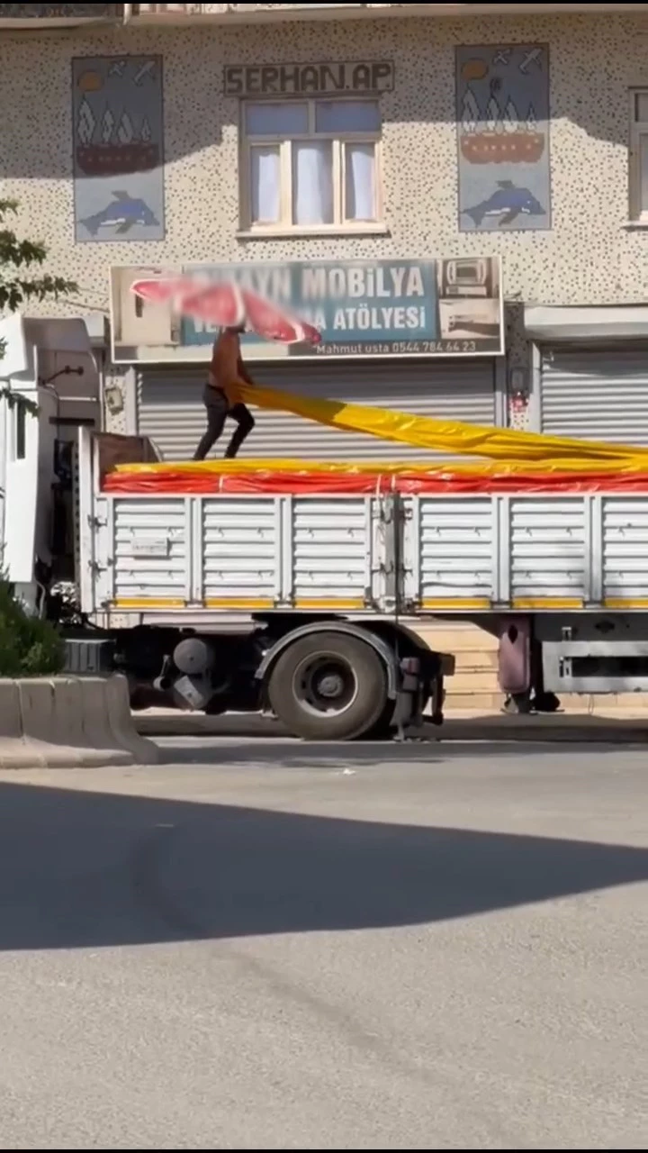 Kavurucu sıcakta beline bağladığı plaj şemsiyesi ile çalıştı