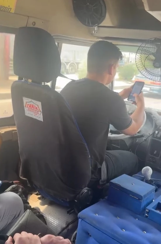 Dolmuş şoförü, direksiyon başında telefonla oynayıp sigara içti