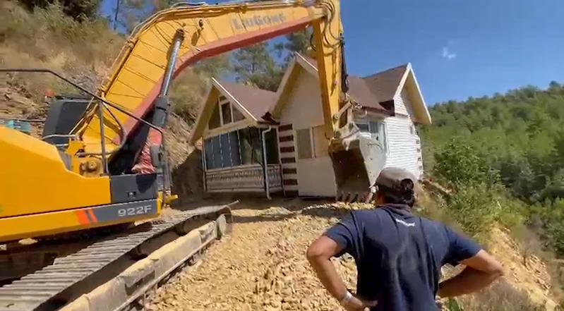 Yıkım kararı verilen konteyner evini iş makinesiyle karadan rayla yürütüp taşıdı